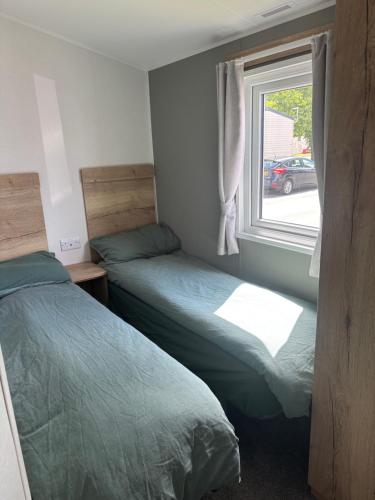 zwei Betten in einem kleinen Zimmer mit Fenster in der Unterkunft Ash 19 in Newton