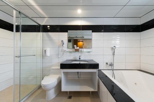 a bathroom with a sink and a toilet and a tub at Sir Motel - Sanchong in Taipei