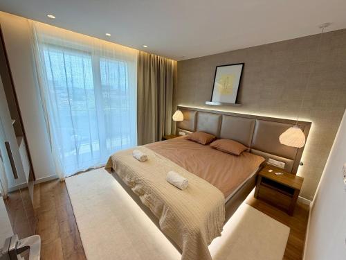 a bedroom with a large bed and a large window at Rupphill Apartment in Budapest