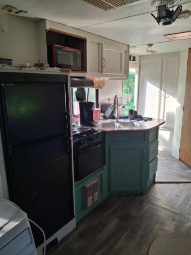 an old kitchen with a stove and a sink at Private Cozy Camper in Burnside