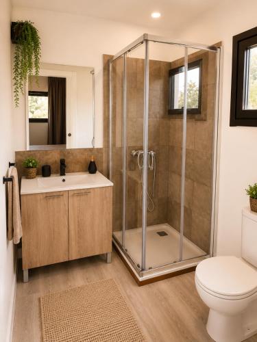 a bathroom with a shower and a sink and a toilet at Green House in Llagostera