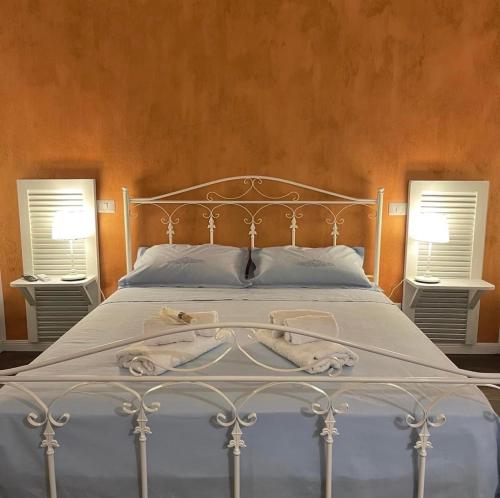 a bedroom with a white bed with two windows at Civico 210 in Itri