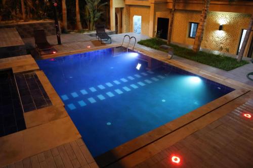 a swimming pool with blue water at night at Villa aya in Oujda