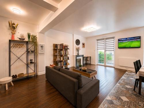 a living room with a couch and a tv at Cosy Normandy - Bloom in Sourdeval