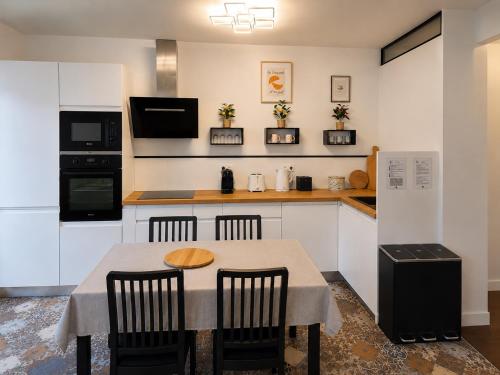 a kitchen with a table and chairs in it at Cosy Normandy - Bloom in Sourdeval