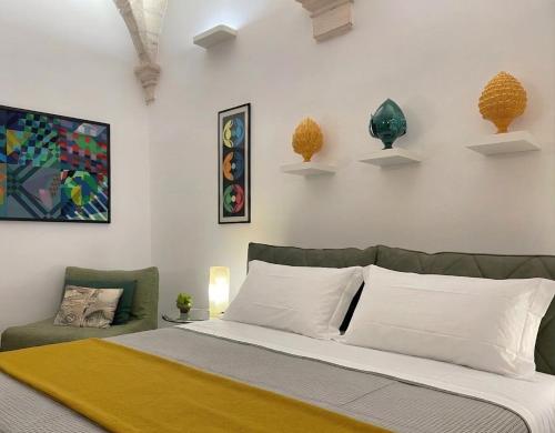 a bedroom with a bed and a couch and vases on the wall at Domus Settecento in Putignano