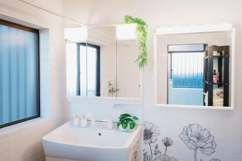 a white bathroom with a sink and a mirror at Nagoya kiyosu温もりの宿貸切一軒家駅近3分 in Nishi-biwajima