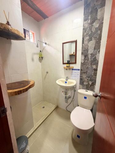 a small bathroom with a toilet and a sink at Hostal Nomadax Tayrona in El Zaino