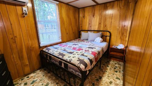 a small bedroom with a bed in a wooden wall at Lee's Grand Lake Resort Cabin 4 in Grove