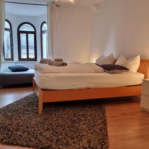 a large bed in a room with a rug at Apartment am Rathaus in Quedlinburg
