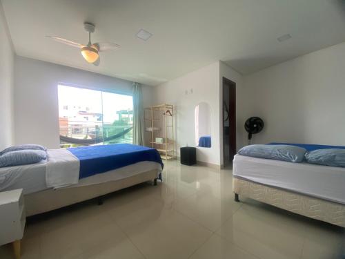 a bedroom with two beds and a window at Requinte e Conforto na Praia do Morro in Guarapari