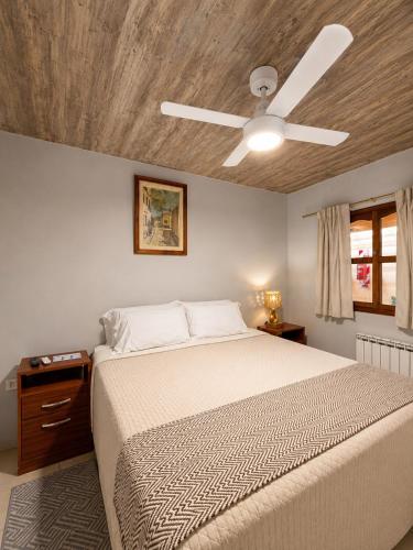 a bedroom with a bed with a ceiling fan at Hotel Belgrano in Tilcara