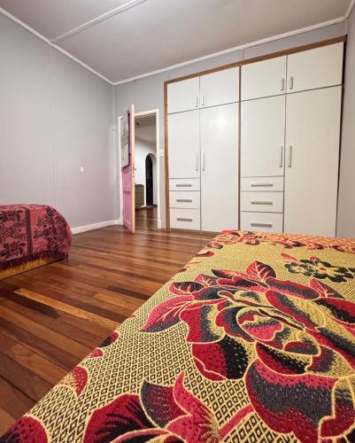 a bedroom with white cabinets and a bed with a rug at Barrio Parque Residence in Caleta Olivia