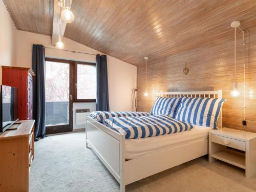 a bedroom with a bed with blue and white stripes at Familien Lodge Fleckalm in Kirchberg in Tirol