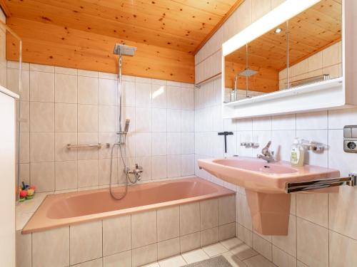 a bathroom with a pink tub and a sink at Familien Lodge Fleckalm in Kirchberg in Tirol