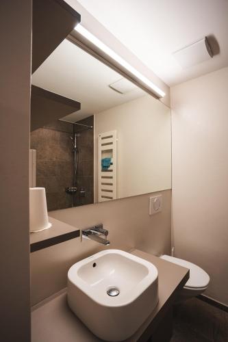 a bathroom with a white sink and a mirror at Pension Longhin Maloja - Self Check In in Maloja
