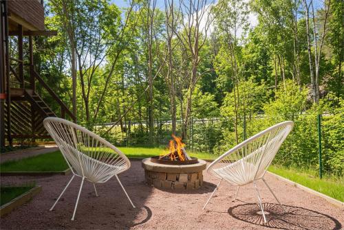 two white chairs sitting in front of a fire pit at the Little Oasis In Gothenburg in Gothenburg