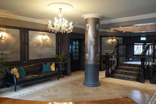 a lobby with a large column and a chandelier at Benedicts Hotel in Belfast