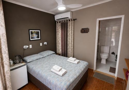 a bedroom with a bed with two towels on it at Hospedaje Los Vencejos in Puerto Iguazú