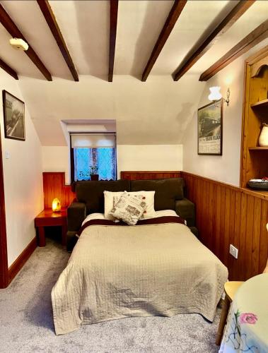 a bedroom with a bed and a couch at The Old Mill and Cottage in Matlock