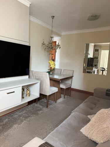 a living room with a television and a dining room table at Apartamento Serra Espírito Santo in Serra