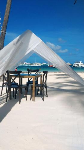 a table and chairs under a tent on the beach at Coral Beach Hotel Punta Cana in Punta Cana