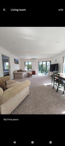 a large living room with a couch and a table at Mount Handy Dandy in Mount Maunganui