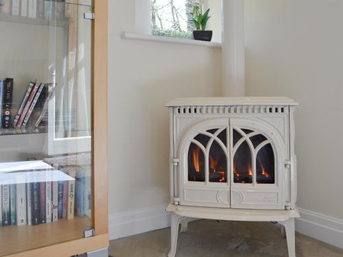 a fireplace in a room next to a book shelf at Dewsnap Spring- Rtt4 in Chinley