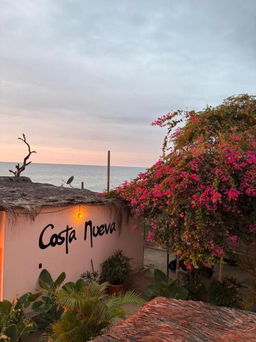 a sign for a costa negra restaurant with pink flowers at Costa Nueva Hotel in Zorritos