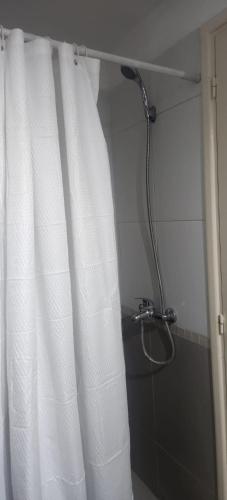 a shower with a white shower curtain in a bathroom at Monoambiente como en casa in Montevideo