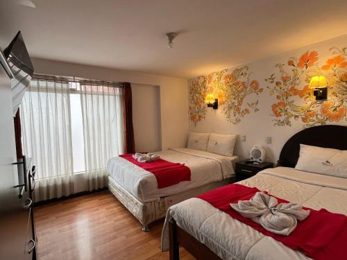 a hotel room with two beds and a tv at La Estancia de la Abuela Cusco Hotel in Cusco