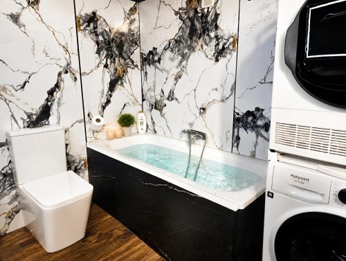 a bathroom with a tub and a toilet and a sink at Big Center Beachfront Apartment in Durrës