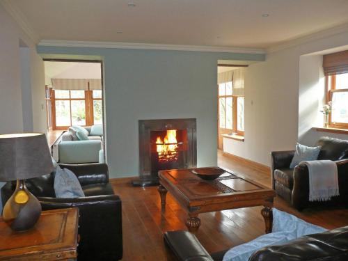 a living room with a couch and a fireplace at Clochridgestone Cottage in Aberargie