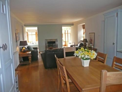 a living room with a table with flowers on it at Clochridgestone Cottage in Aberargie