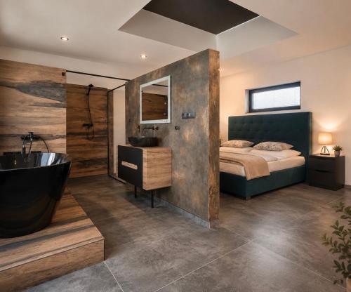 a bedroom with a bed and a bath tub in it at Apartmán Natalka7 in Bartovice