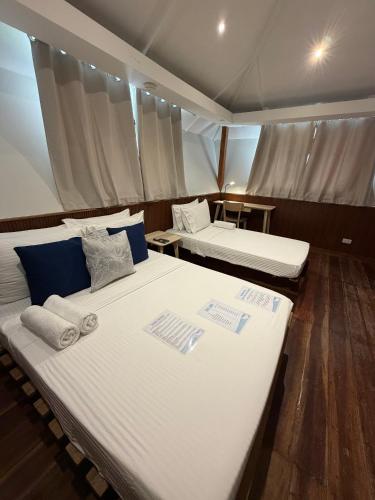 a room with two beds and a table at Casitas de Boracay in Boracay
