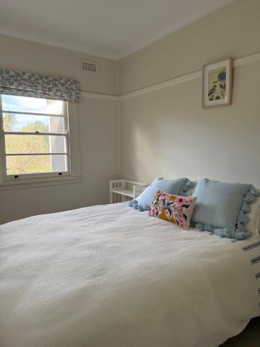 a bedroom with a large white bed with a window at Namoi Dreaming Spacious parkview residence in Narrabri