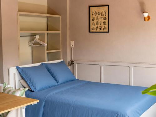 a bedroom with a blue bed and a mirror at Appartement confortable avec cuisine équipée - API-1-52-759 in Granges-Aumontzey