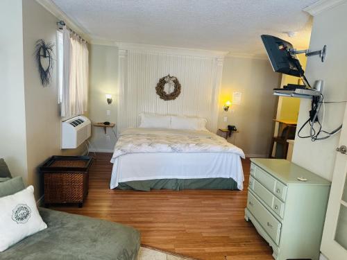 ein Schlafzimmer mit einem weißen Bett und einem Holzboden in der Unterkunft Glenview Cottages in Sault Ste. Marie