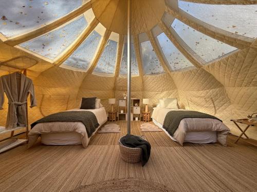 a bedroom with two beds in a tent at Forest Hillside Glamping Retreat in Lochiel