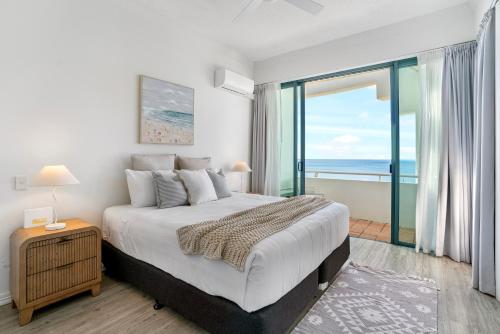 a bedroom with a bed with a view of the ocean at Alexandra on the Pacific in Mooloolaba