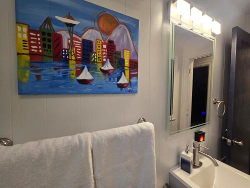a bathroom with a sink and a painting of boats at 2BR House Perfect for Olympic NP Adventures in Port Angeles