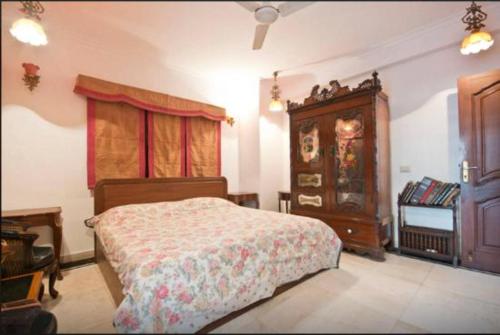 a bedroom with a bed and a dresser at Villa 33 in New Delhi