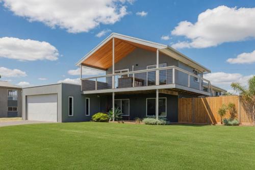 a house with a large yard with green grass at Island Getaway Cape Woolamai in Cape Woolamai