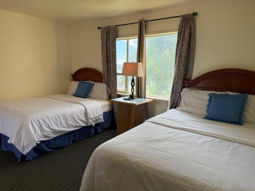 a hotel room with two beds and a window at Lakeside Motel in Moses Lake