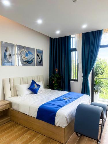 a bedroom with a large bed with blue curtains at Hotel Trung Đông 2 in Ấp Bình Thương