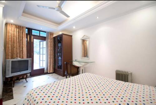 a bedroom with a bed and a flat screen tv at Villa 33 in New Delhi