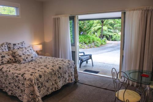 ファンガマタにあるAmazing Kiwi Lodgeのベッドルーム1室(ベッド1台付)、スライド式ガラスドアが備わります。