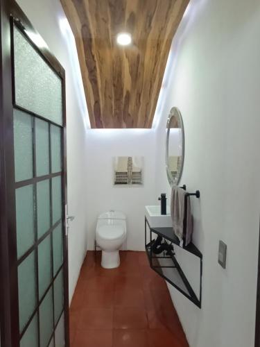 a bathroom with a toilet and a mirror at Hotel Casa Capadose in Tlayacapan