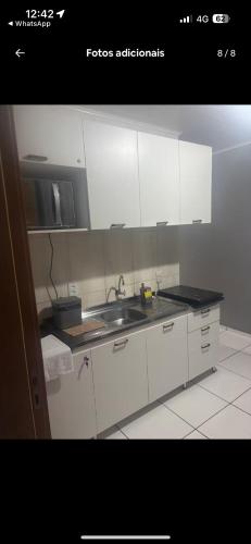 a kitchen with white cabinets and a sink at Apartmento-Studio in União da Vitória